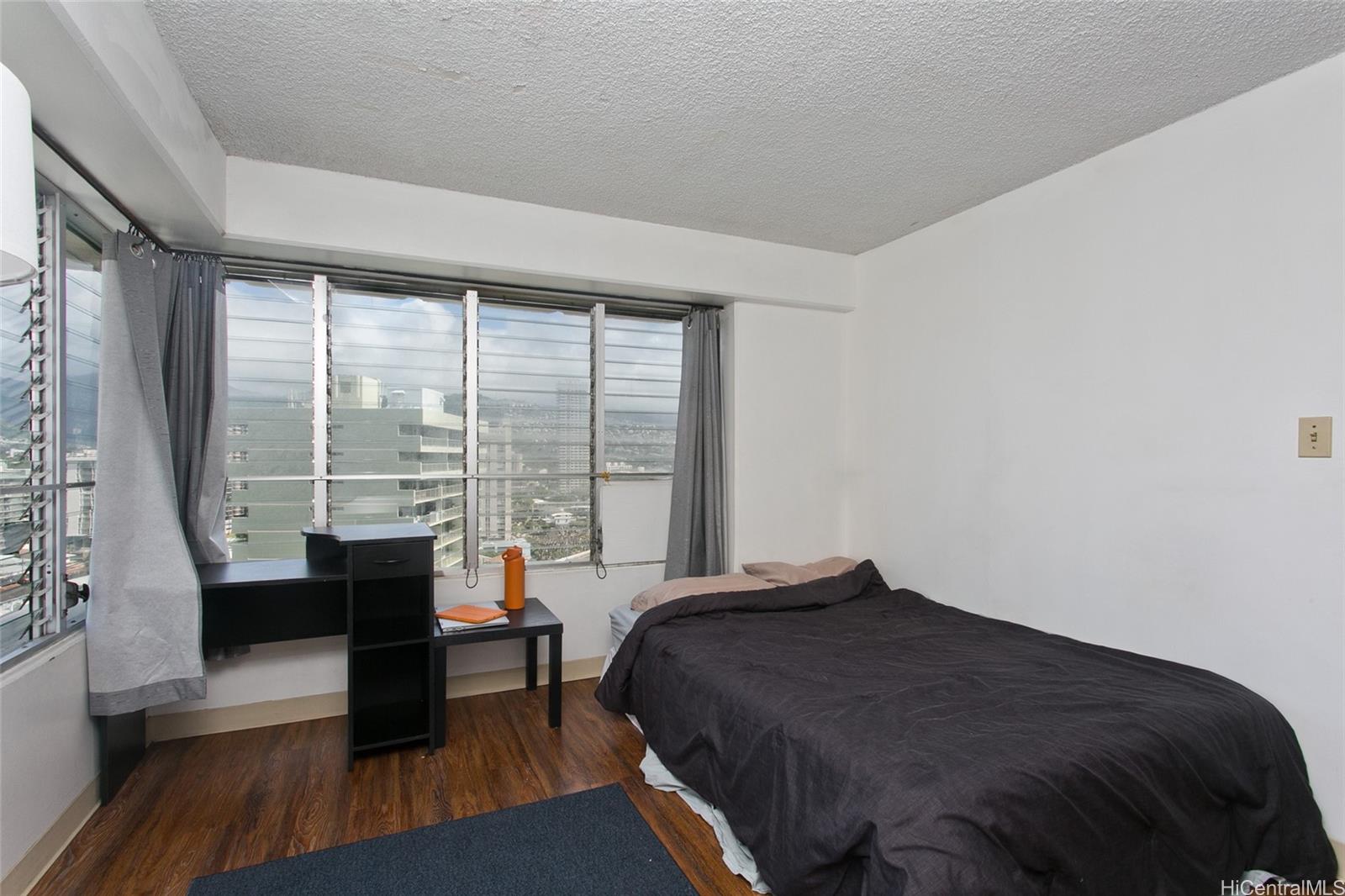 2525 Date Street, Unit 1705 Honolulu, HI 96826 - Photo 7 of 11 a bedroom with a bed and a large window