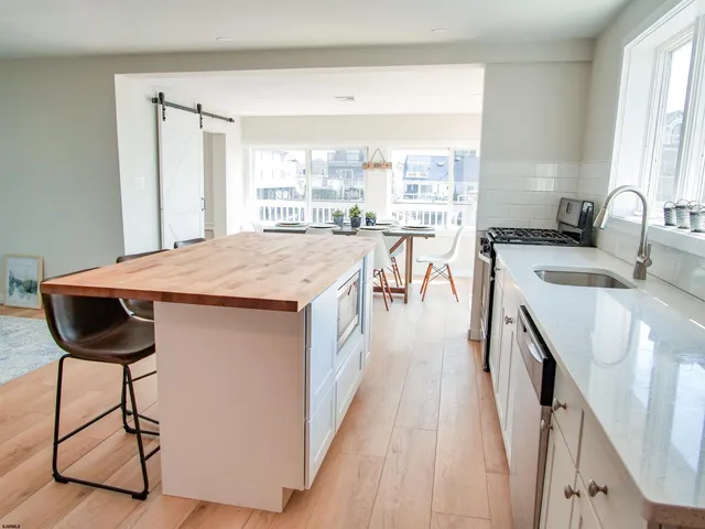 a open kitchen with stainless steel appliances granite countertop a stove a sink and a refrigerator