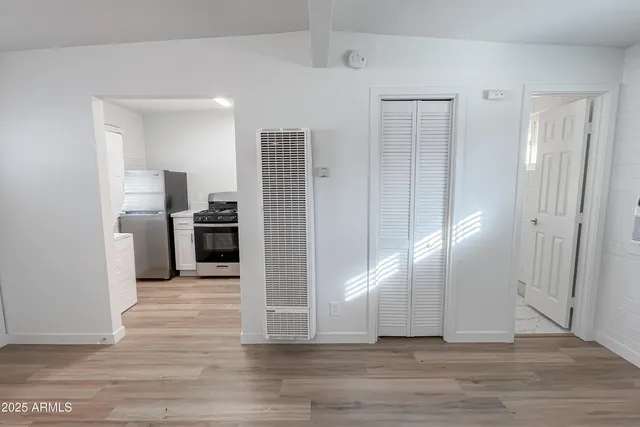 a view of a kitchen with wooden floor and electronic appliances