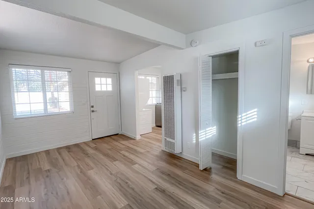 an empty room with wooden floor and windows