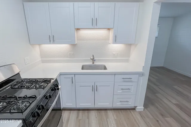 a kitchen with white cabinets and appliances