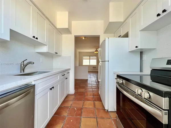 a kitchen with granite countertop a stove and a refrigerator