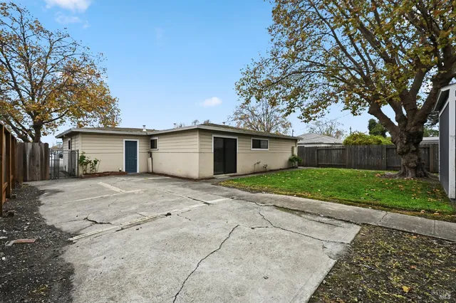 a view of a house with a yard and large tree