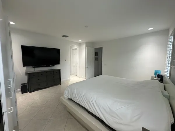 a bedroom with a bed and a flat screen tv