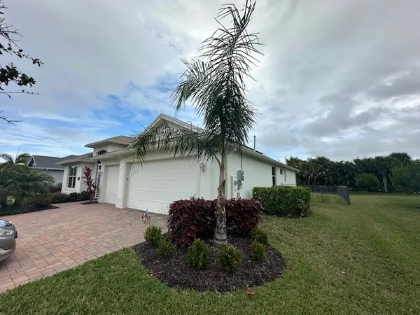 a view of a house with a yard and potted plants