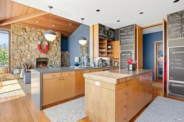 a kitchen that has a lot of cabinets in it and wooden floor