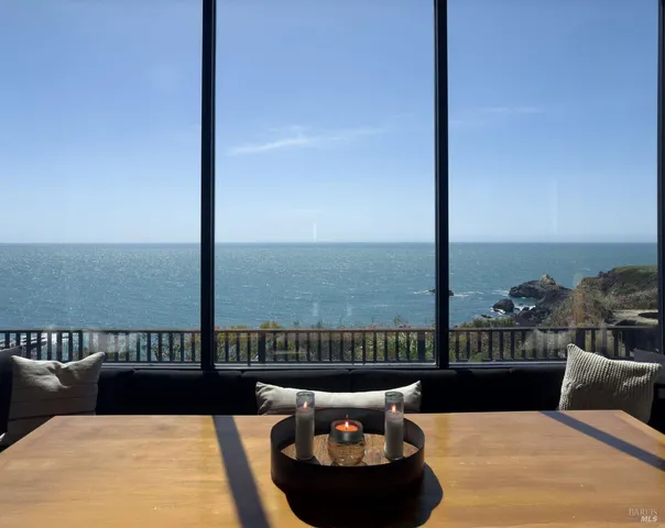 a roof deck with couches and ocean view