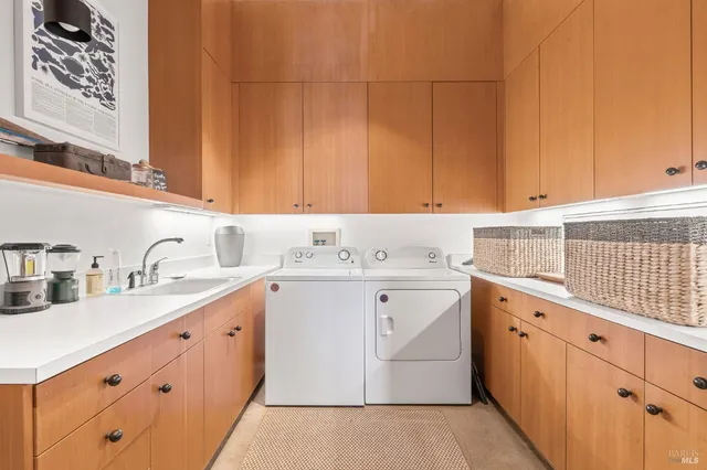 a utility room with cabinets washer and dryer