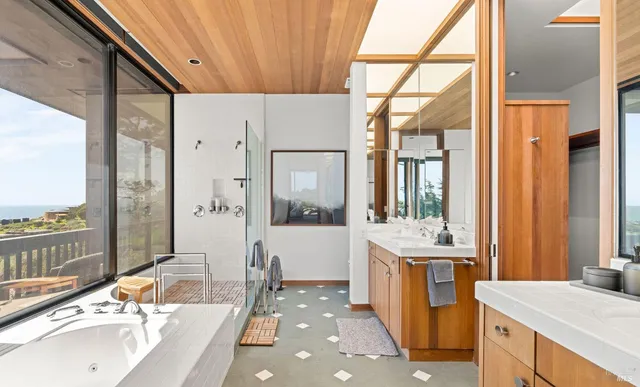 a bathroom with a double vanity sink a mirror and a bathtub
