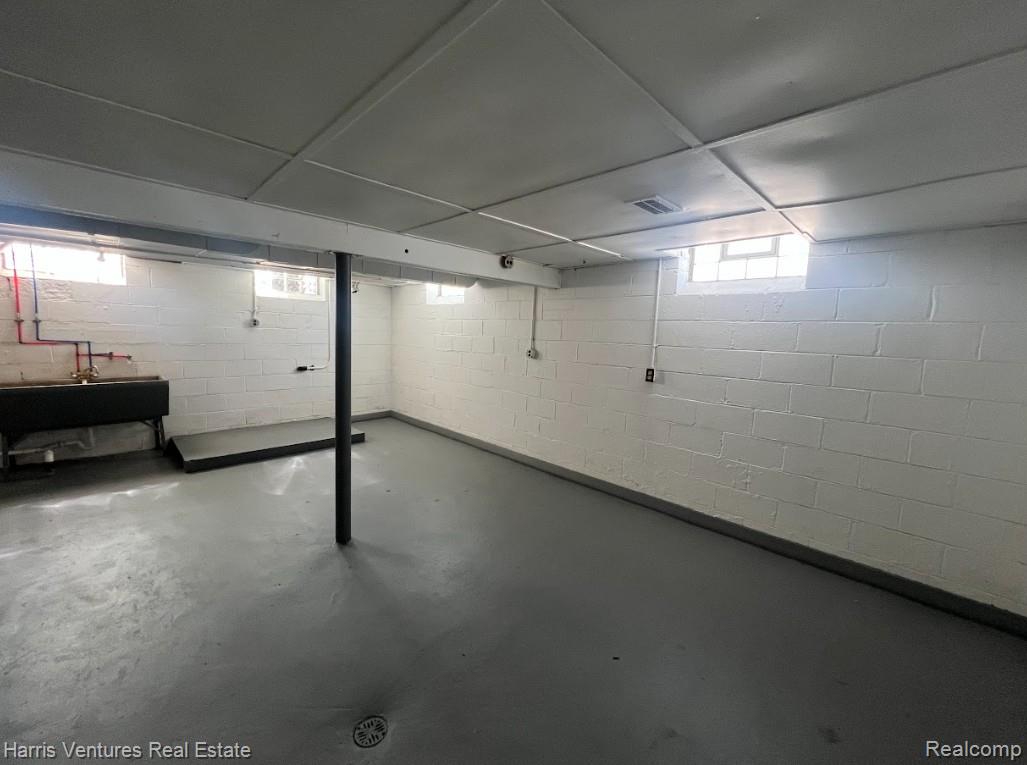 22144 Moross Road Grosse Pointe, MI 48236 - Photo 16 of 16 Spacious utility area featuring concrete block walls, painted concrete flooring, and a drop-tile ceiling