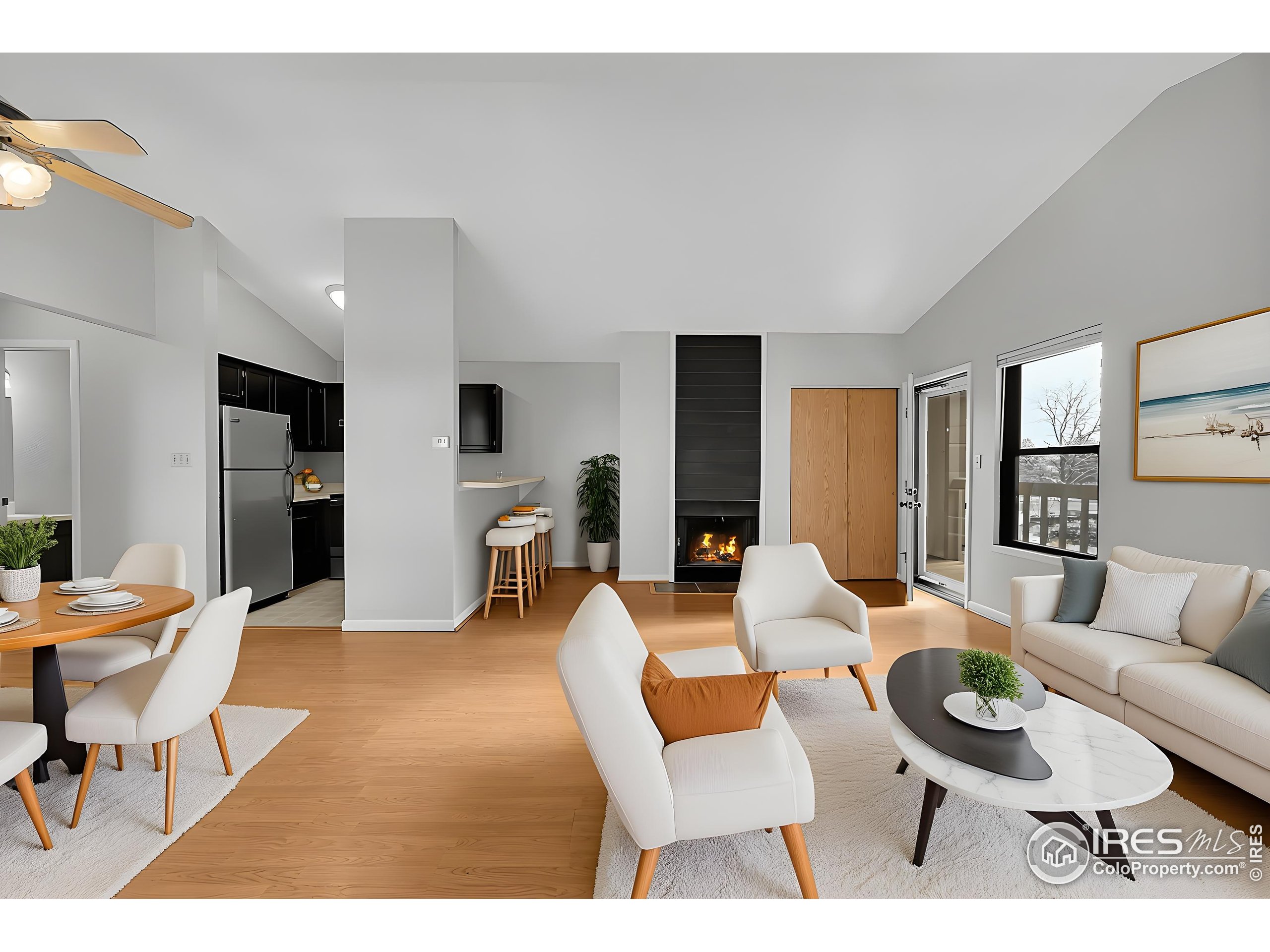 a living room with furniture a large window and stainless steel appliances