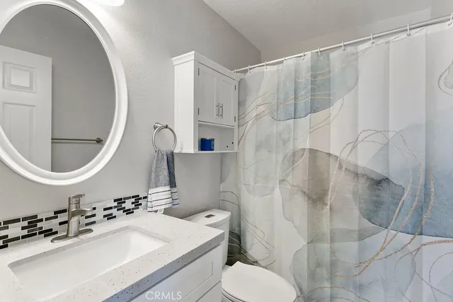 a bathroom with a sink a toilet and a mirror