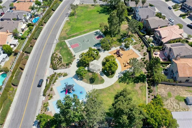 an aerial view of residential house with outdoor space and trees all around