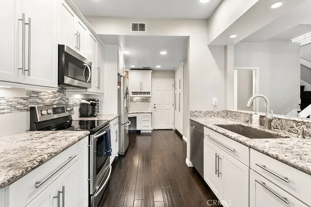 a kitchen with stainless steel appliances granite countertop a sink stove oven and refrigerator