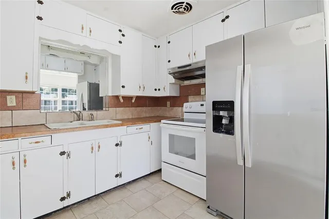 a kitchen with granite countertop white cabinets and white appliances