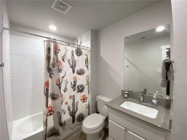 a bathroom with a sink toilet vanity and shower