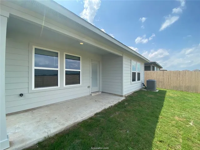 a view of an house with backyard and porch