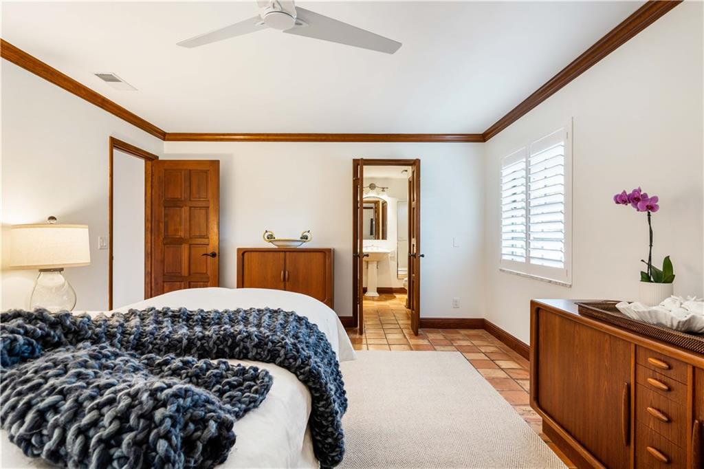 246 Live Oak Road Vero Beach, FL 32963 - Photo 19 of 30 a bedroom with a large bed and a chandelier