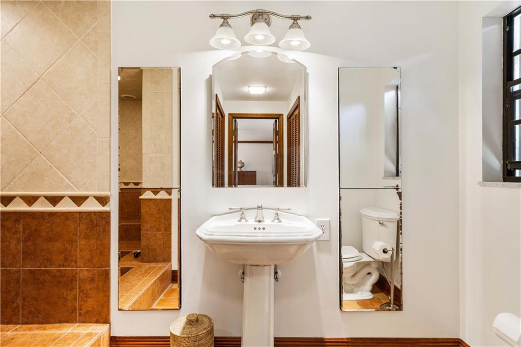 246 Live Oak Road Vero Beach, FL 32963 - Photo 20 of 30 a bathroom with a sink a mirror and a shower