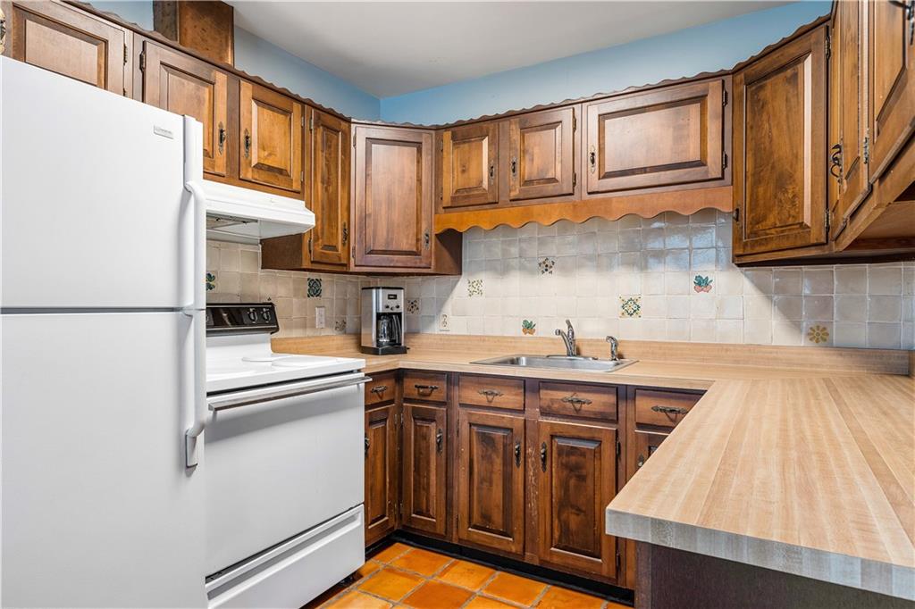 246 Live Oak Road Vero Beach, FL 32963 - Photo 26 of 30 a kitchen with stainless steel appliances granite countertop a refrigerator a sink dishwasher and white cabinets with wooden floor