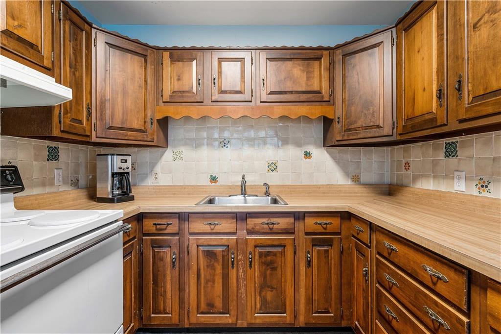 246 Live Oak Road Vero Beach, FL 32963 - Photo 27 of 30 a kitchen with stainless steel appliances granite countertop a sink and cabinets