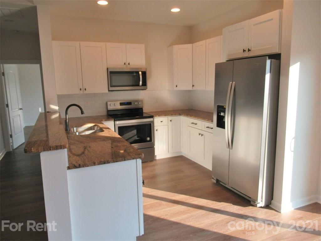 1544 Null Road Lincolnton, NC 28092 - Photo 7 of 22 a kitchen with stainless steel appliances granite countertop a refrigerator a stove and a sink