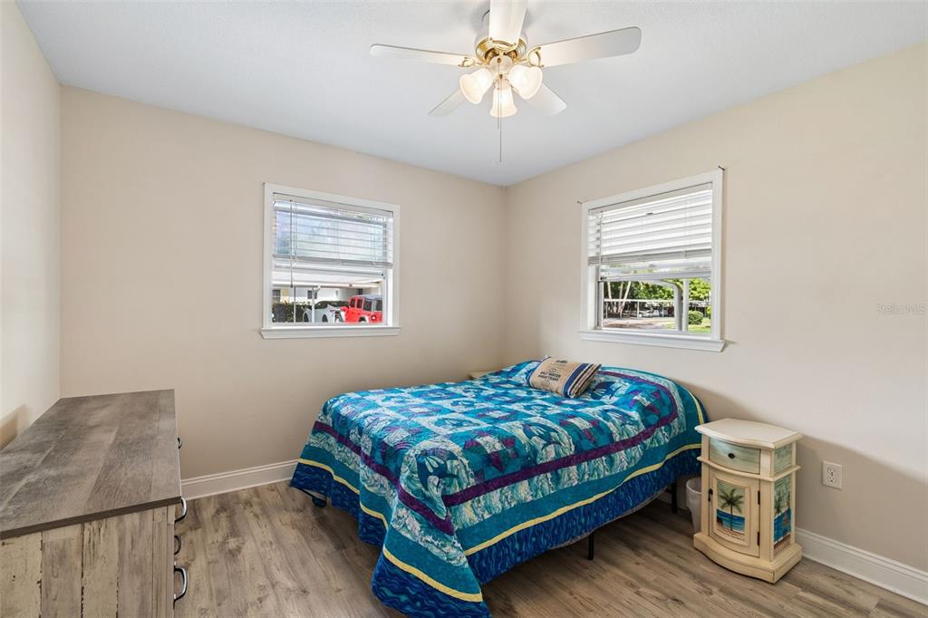 6026 Lilli Way Bradenton, FL 34207 - Photo 11 of 62 a bedroom with a bed chandelier and a window
