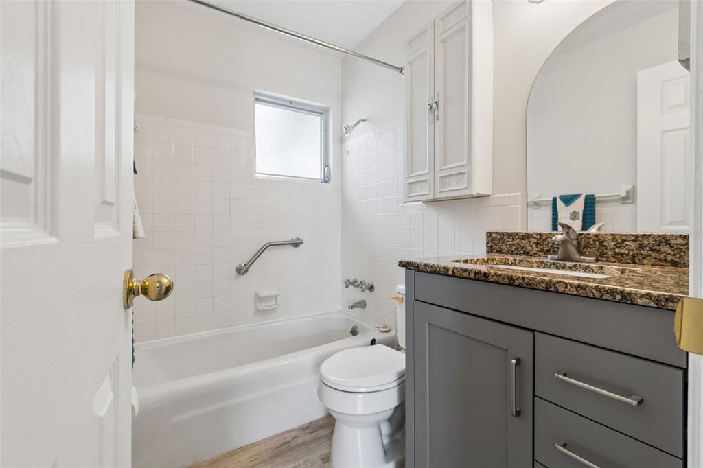 6026 Lilli Way Bradenton, FL 34207 - Photo 13 of 62 a bathroom with a granite countertop toilet a sink and bathtub