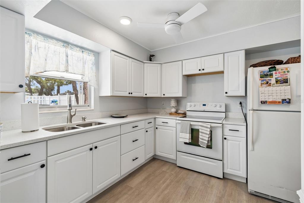 6026 Lilli Way Bradenton, FL 34207 - Photo 36 of 62 a kitchen with white cabinets sink and white appliances