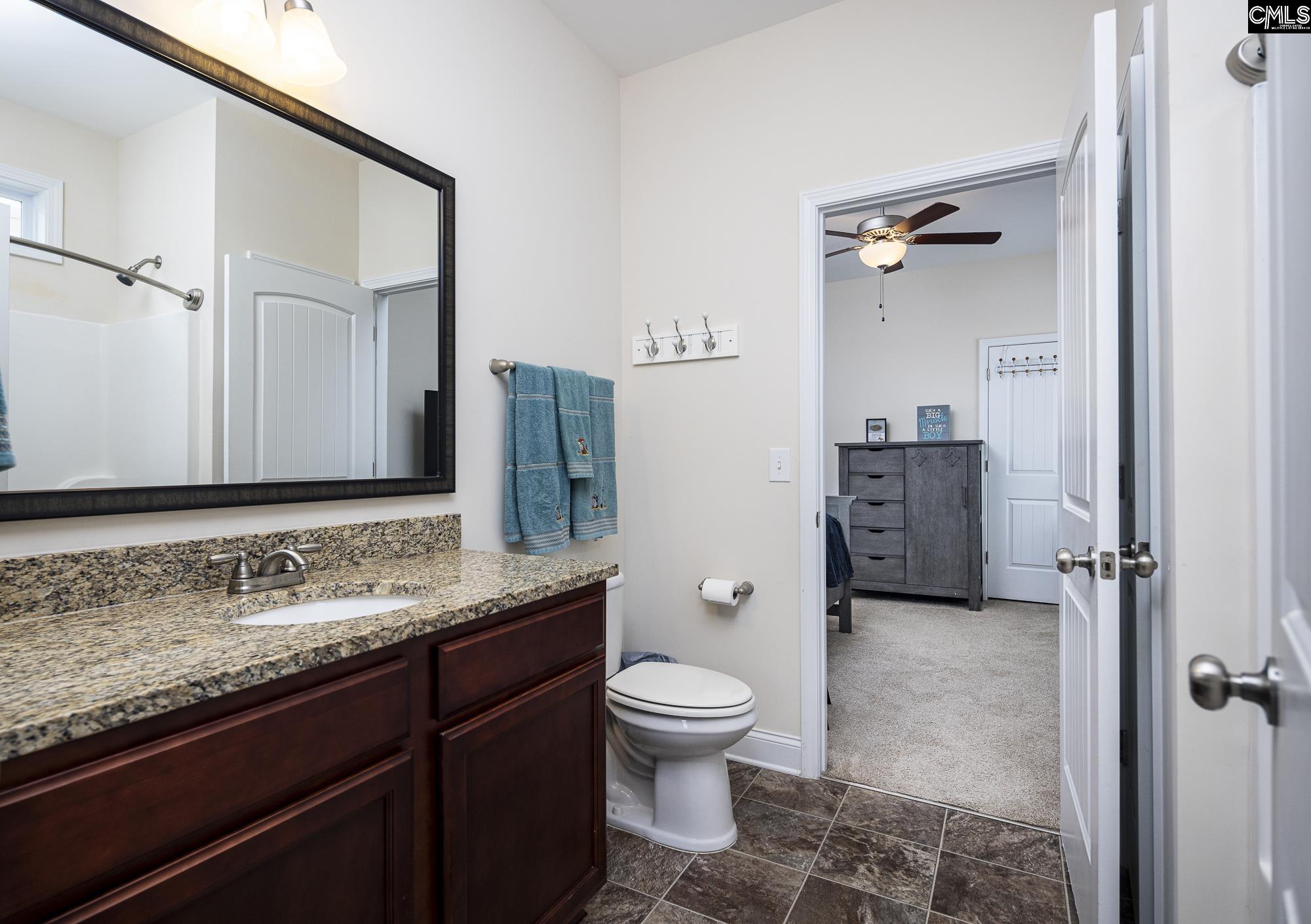 213 Sunset Point Drive Lexington, SC 29072 - Photo 27 of 35 a bathroom with a granite countertop sink toilet mirror and shower