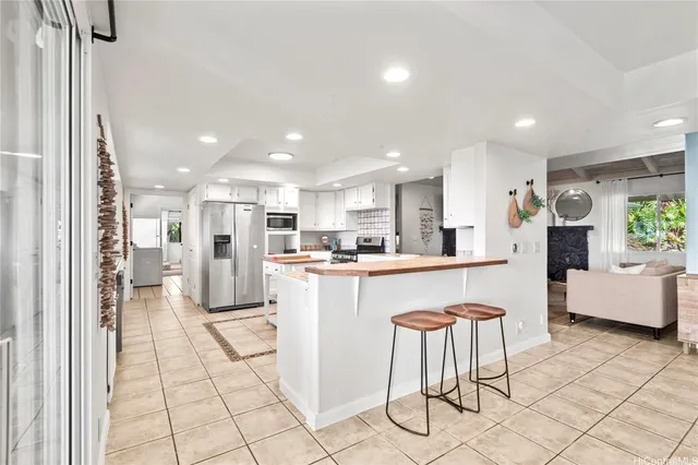 a kitchen with stainless steel appliances kitchen island granite countertop a refrigerator and a sink