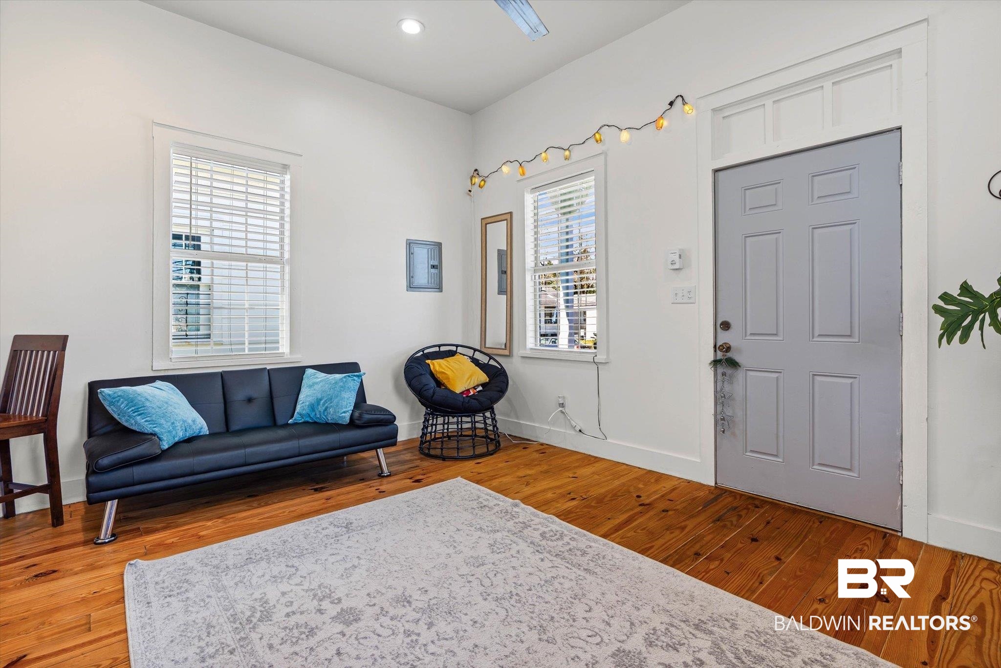 951 Montgomery Street Mobile, AL 36604 - Photo 5 of 22 Bright interior space featuring wood-finish flooring and a light gray six-panel entry door with transom detailing