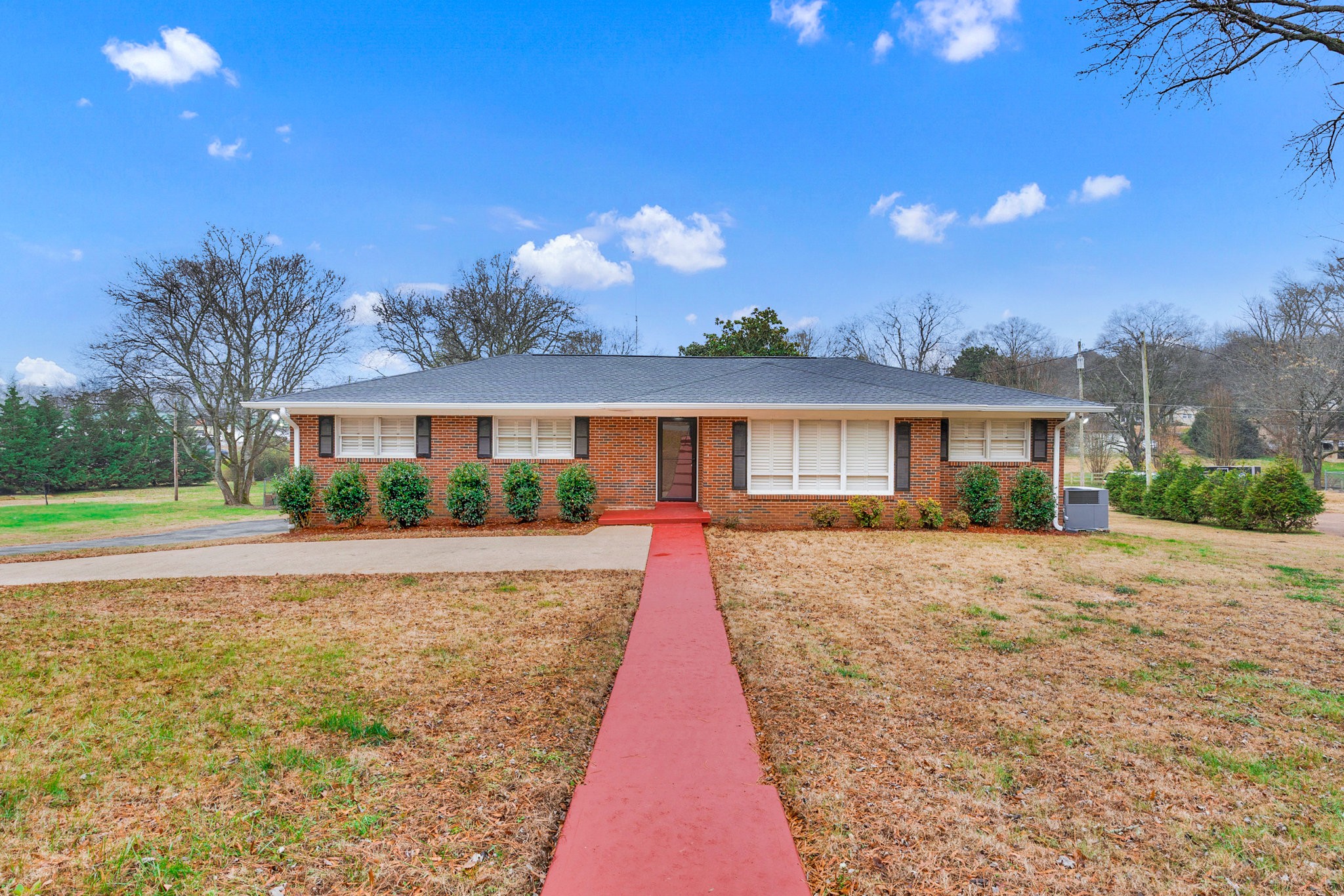 a view of a house with a yard and potted plants