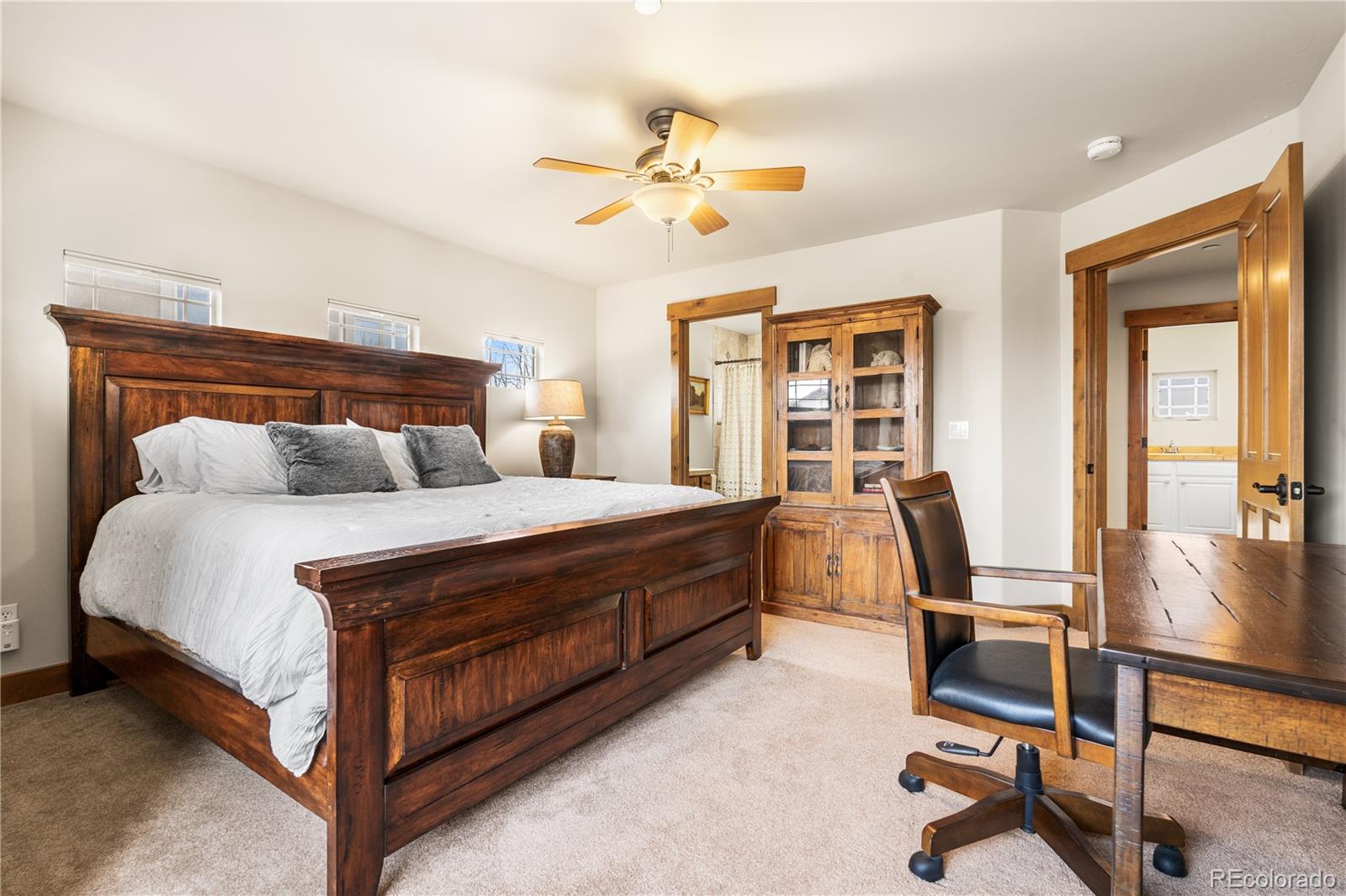 1251 Buffalo Ridge Road Castle Pines, CO 80108 - Photo 32 of 50 a bedroom with a bed and a chandelier
