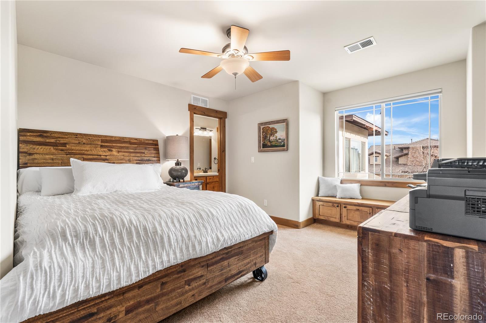 1251 Buffalo Ridge Road Castle Pines, CO 80108 - Photo 34 of 50 a bedroom with a large bed and a chandelier
