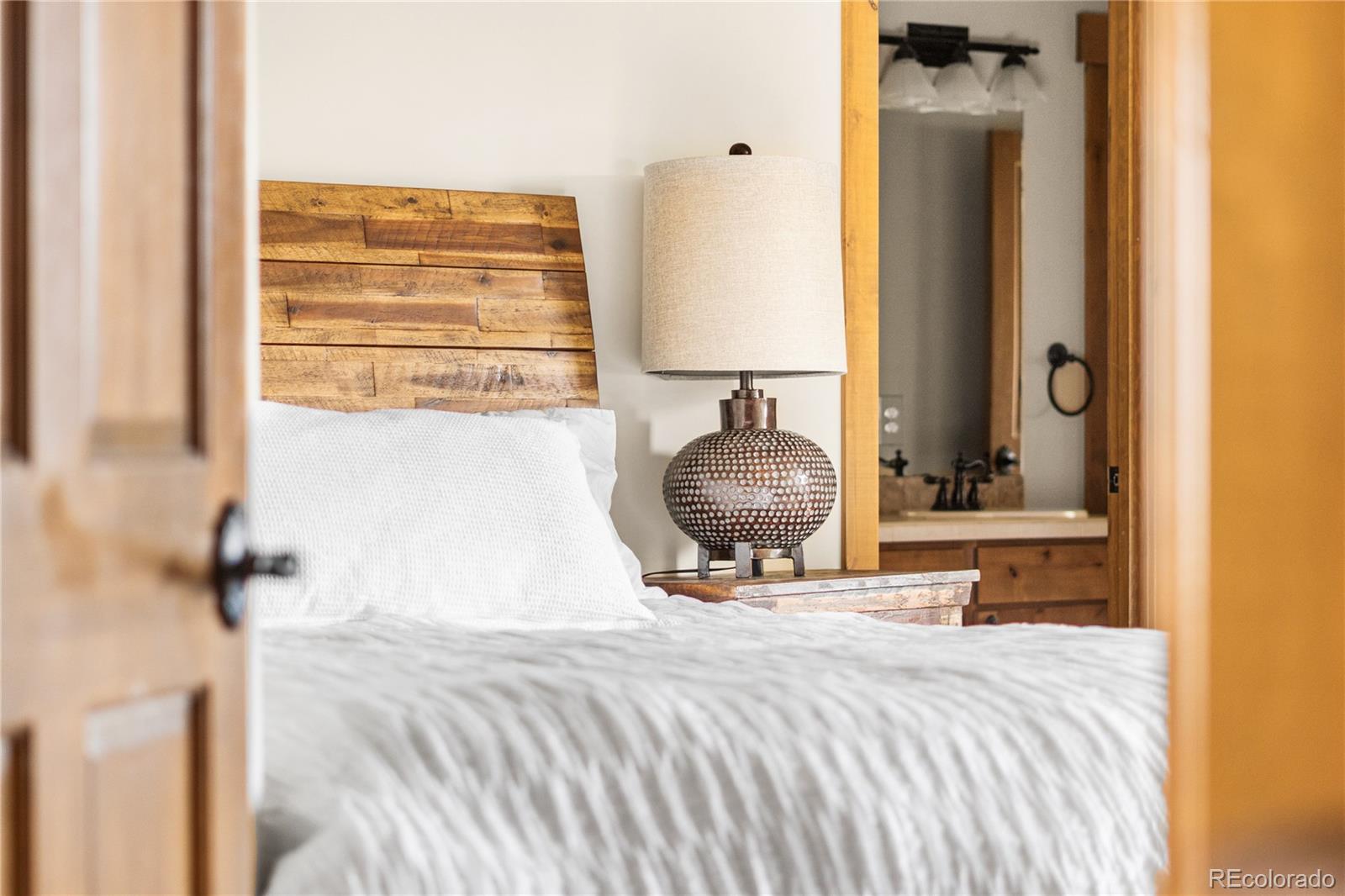 1251 Buffalo Ridge Road Castle Pines, CO 80108 - Photo 35 of 50 a bedroom with a bed and a mirror