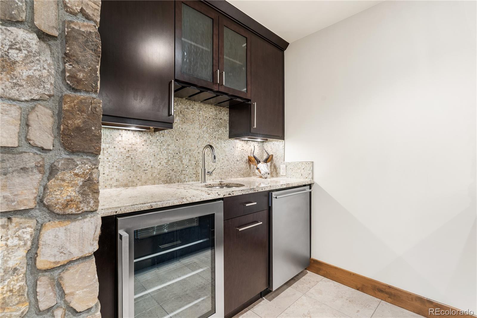 1251 Buffalo Ridge Road Castle Pines, CO 80108 - Photo 40 of 50 a kitchen with stainless steel appliances a sink stove and cabinets