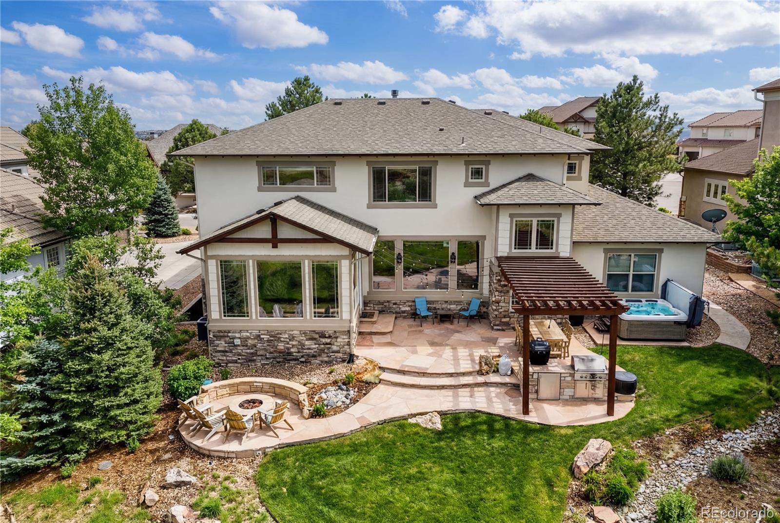 1251 Buffalo Ridge Road Castle Pines, CO 80108 - Photo 6 of 50 a front view of a house with a garden and sitting area