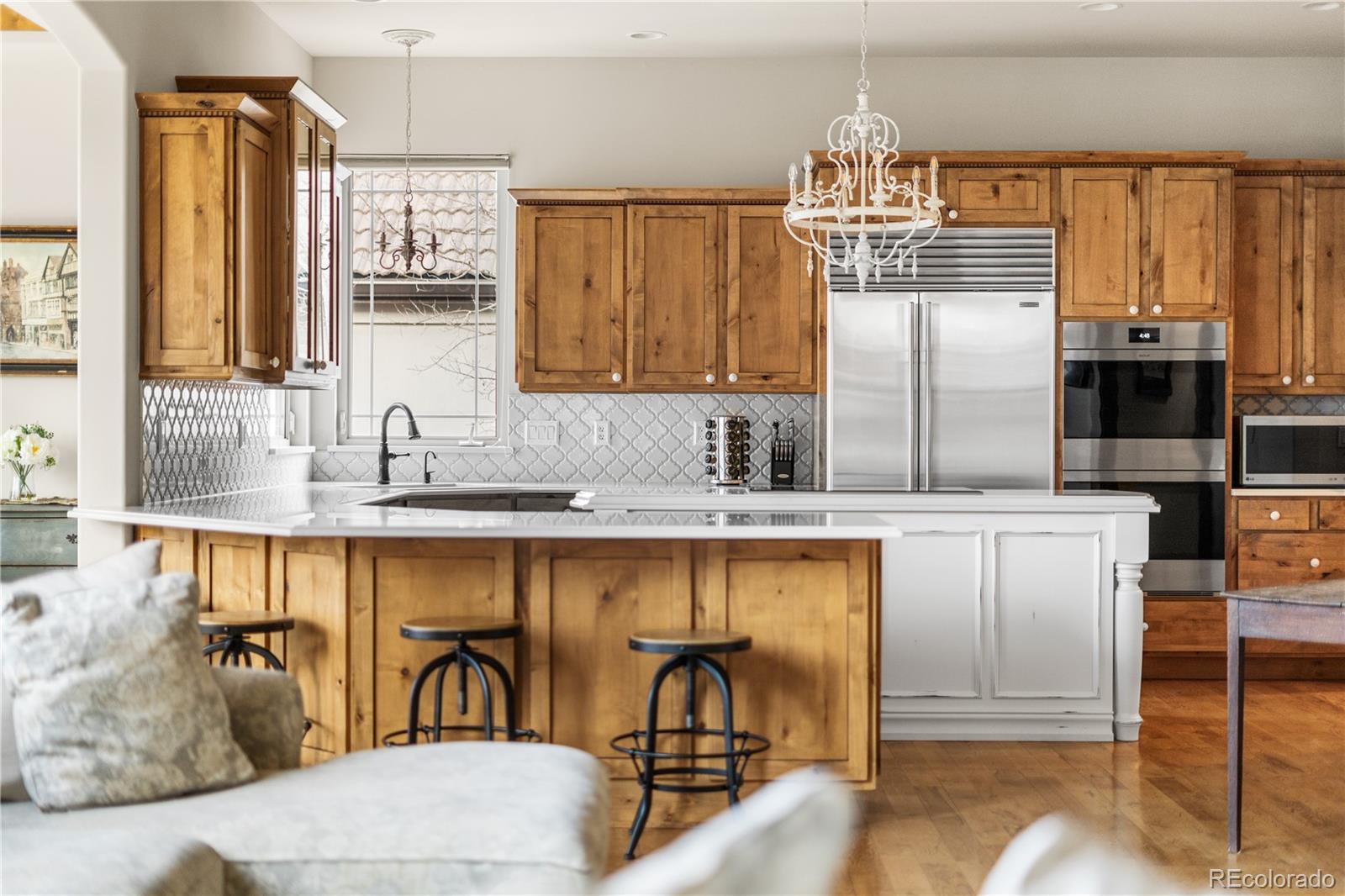 1251 Buffalo Ridge Road Castle Pines, CO 80108 - Photo 9 of 50 a kitchen with stainless steel appliances a sink and cabinets