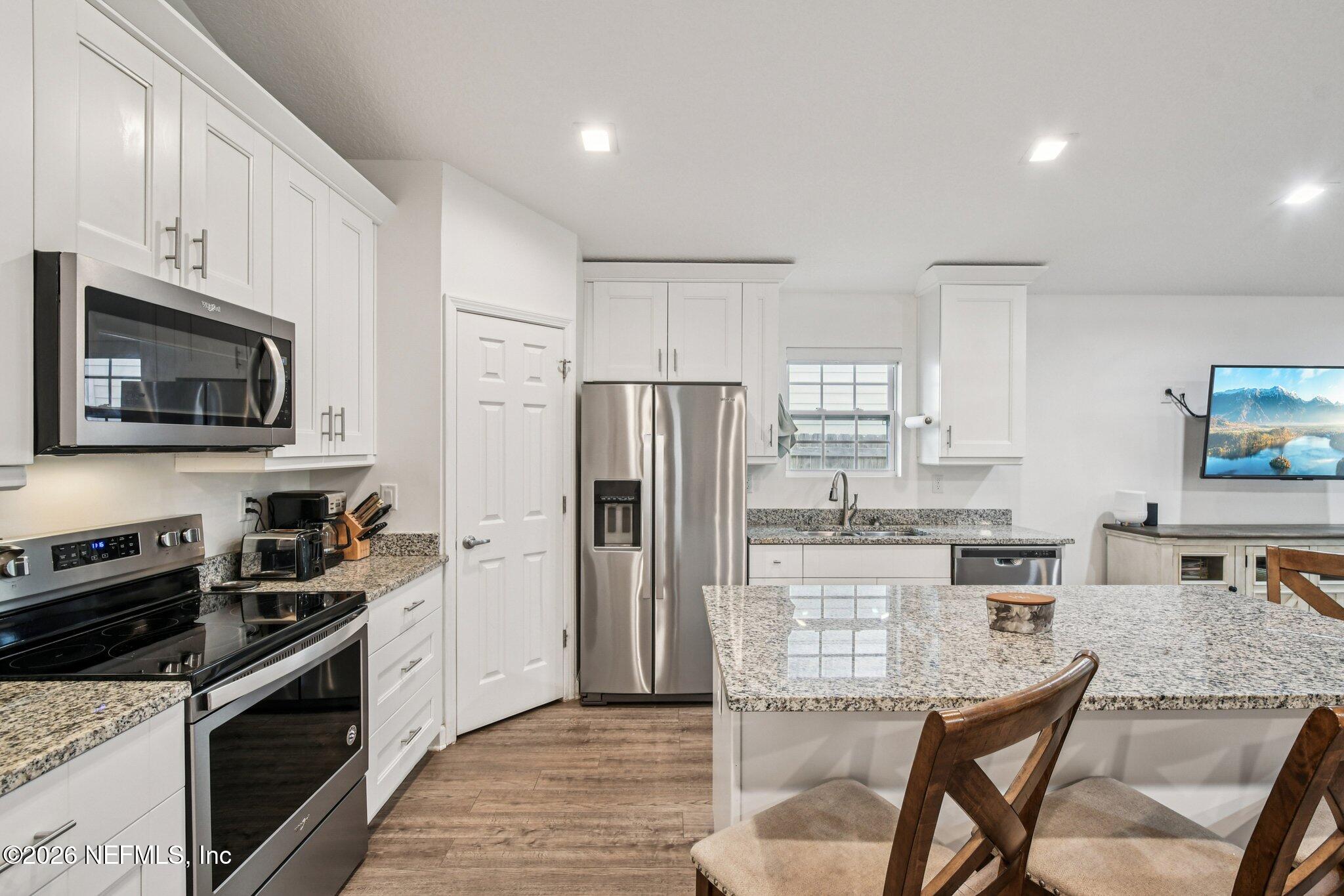 4183 Pine Road Orange Park, FL 32065 - Photo 19 of 62 a kitchen with granite countertop a refrigerator stove microwave and sink