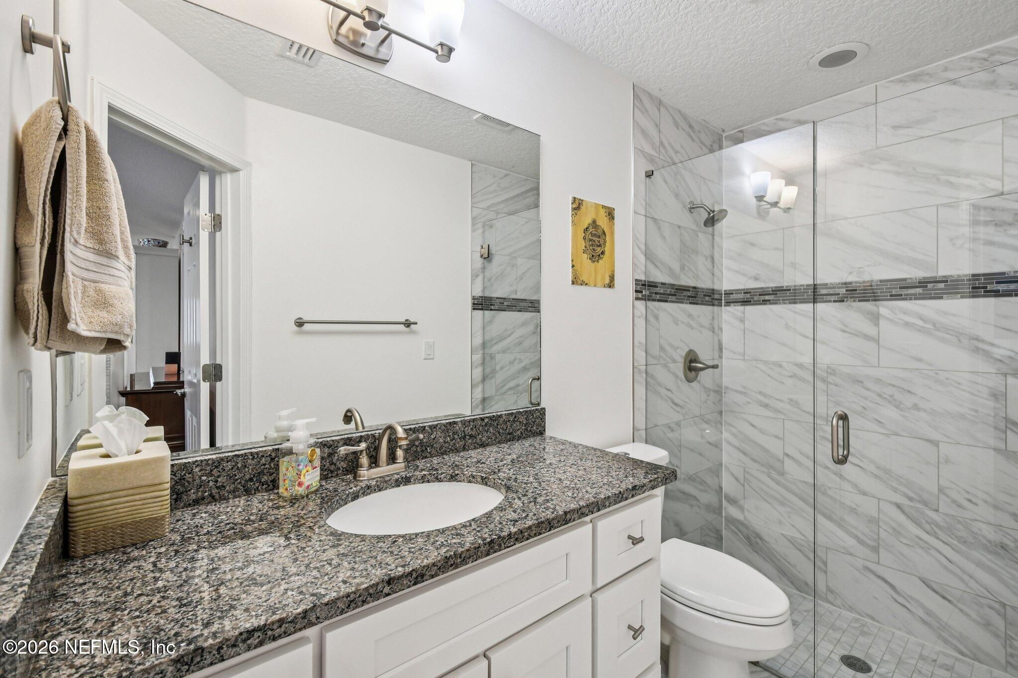 4183 Pine Road Orange Park, FL 32065 - Photo 30 of 62 a bathroom with a granite countertop sink toilet and shower