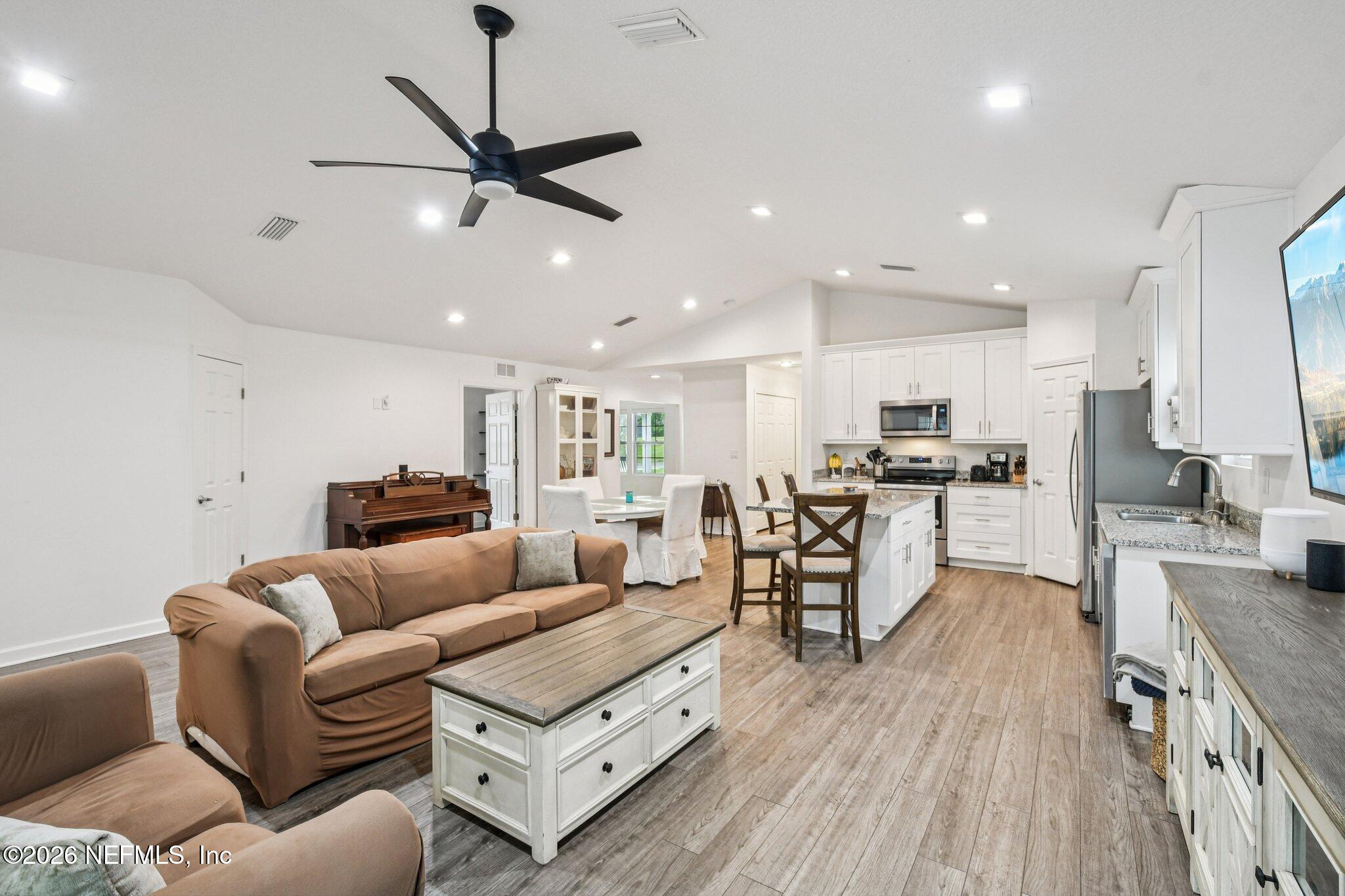 4183 Pine Road Orange Park, FL 32065 - Photo 9 of 62 a living room with furniture kitchen area and a wooden floor