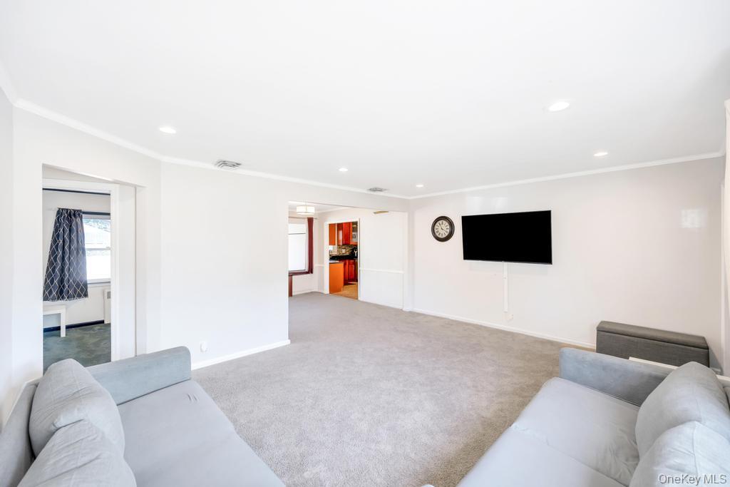 885 Downing Road Valley Stream, NY 11580 - Photo 15 of 36 Living area with light colored carpet, ornamental molding, and recessed lighting