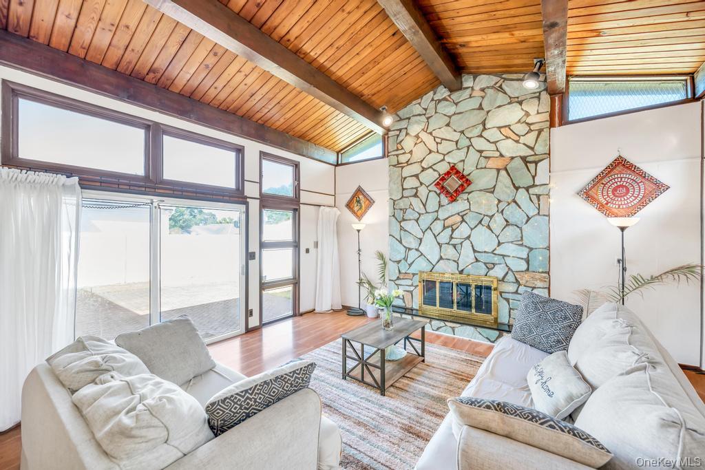 885 Downing Road Valley Stream, NY 11580 - Photo 24 of 36 Living area with wood finished floors, high vaulted ceiling, a fireplace, and a wooden ceiling with exposed beams