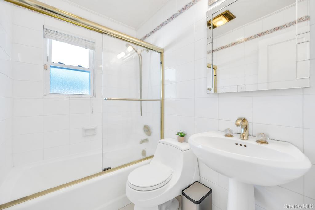 885 Downing Road Valley Stream, NY 11580 - Photo 30 of 36 Full bathroom featuring tile walls and bath / shower combo with glass door