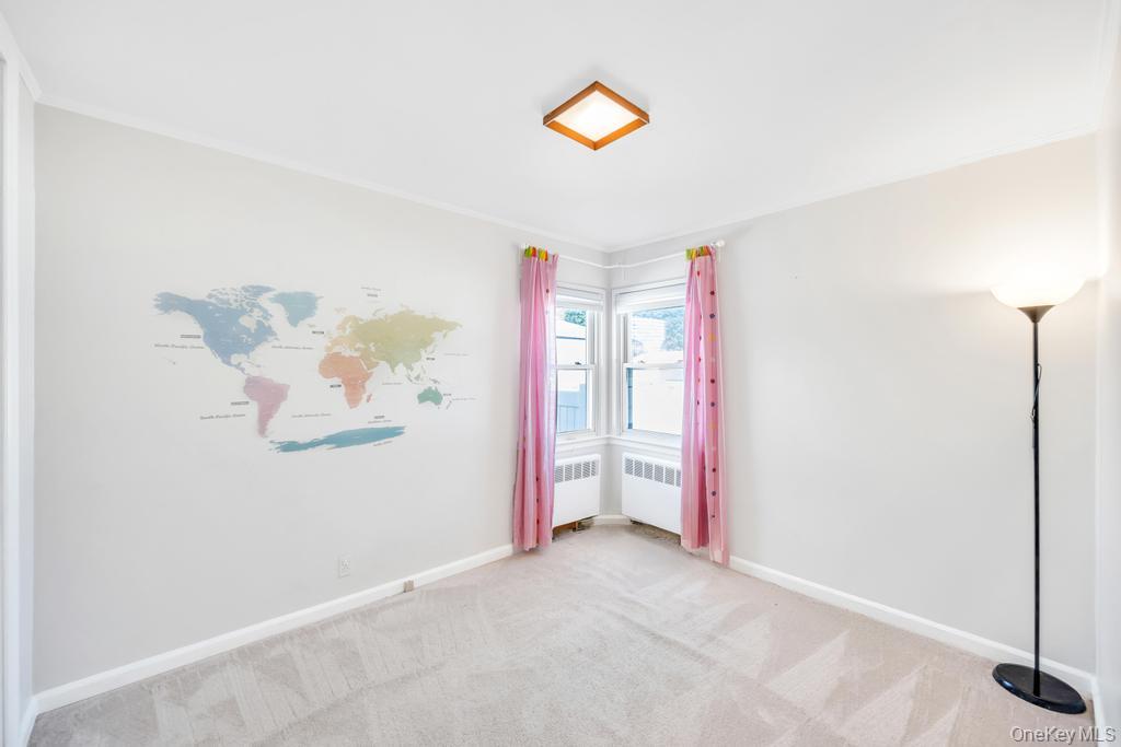 885 Downing Road Valley Stream, NY 11580 - Photo 31 of 36 Empty room with carpet floors, radiator heating unit, and ornamental molding