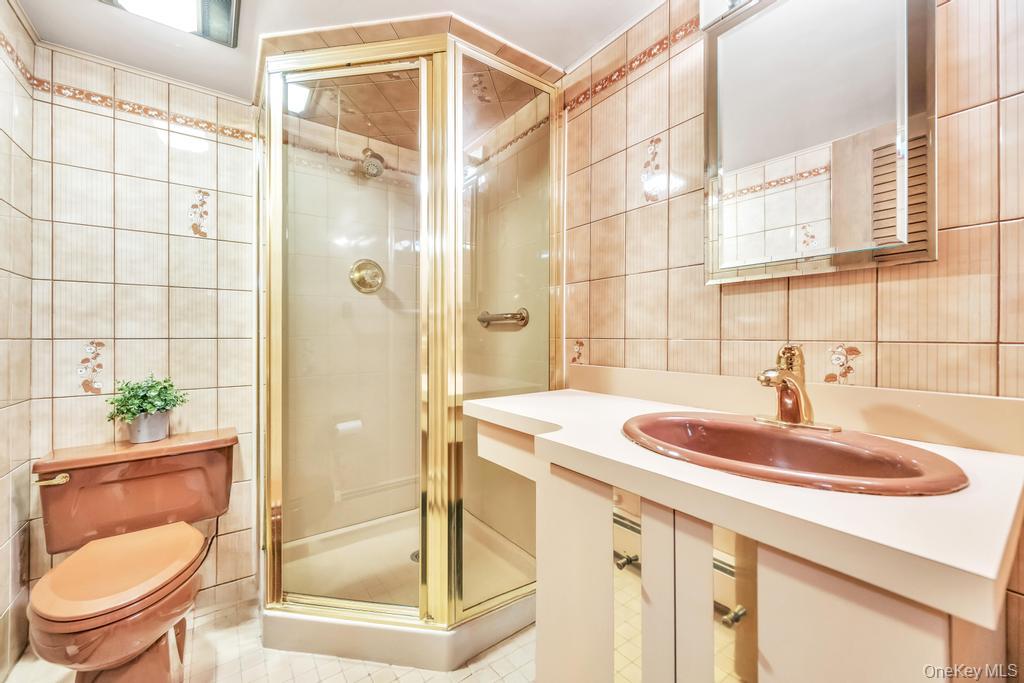 885 Downing Road Valley Stream, NY 11580 - Photo 36 of 36 Full bathroom featuring tile walls, a stall shower, tile patterned flooring, and vanity