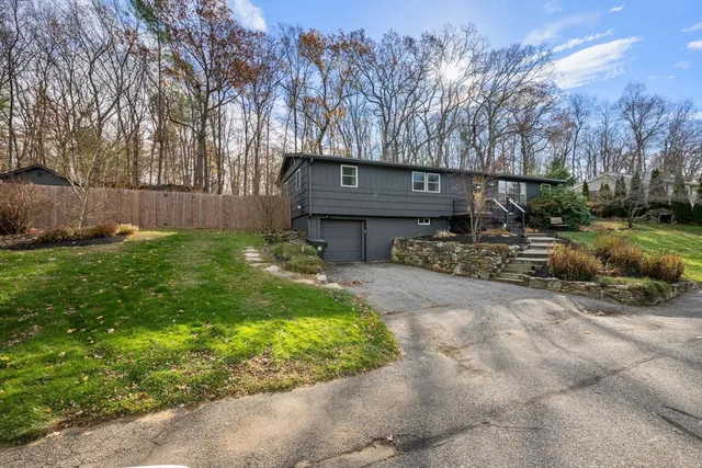 a view of backyard with wooden fence and large trees