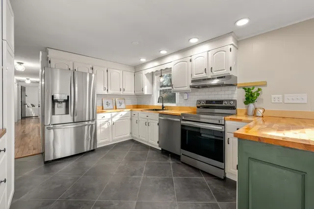 a kitchen with stainless steel appliances and white cabinets
