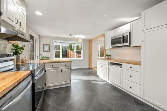 a kitchen with granite countertop white cabinets and white appliances